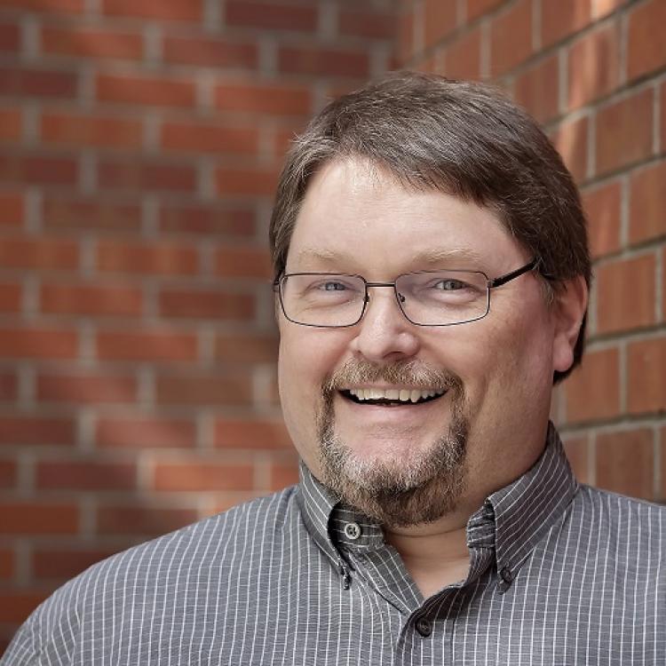 profile of David Cornelius against a brick background